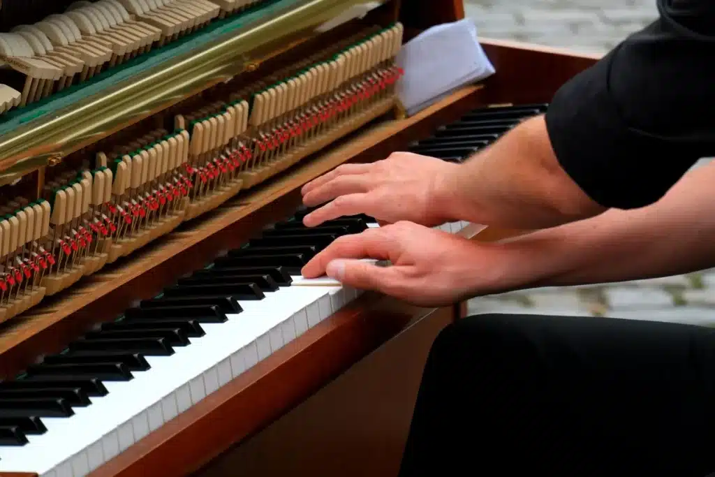 Mains d'un musicien en train de pratiquer sur un instrument, feuille de musique visible