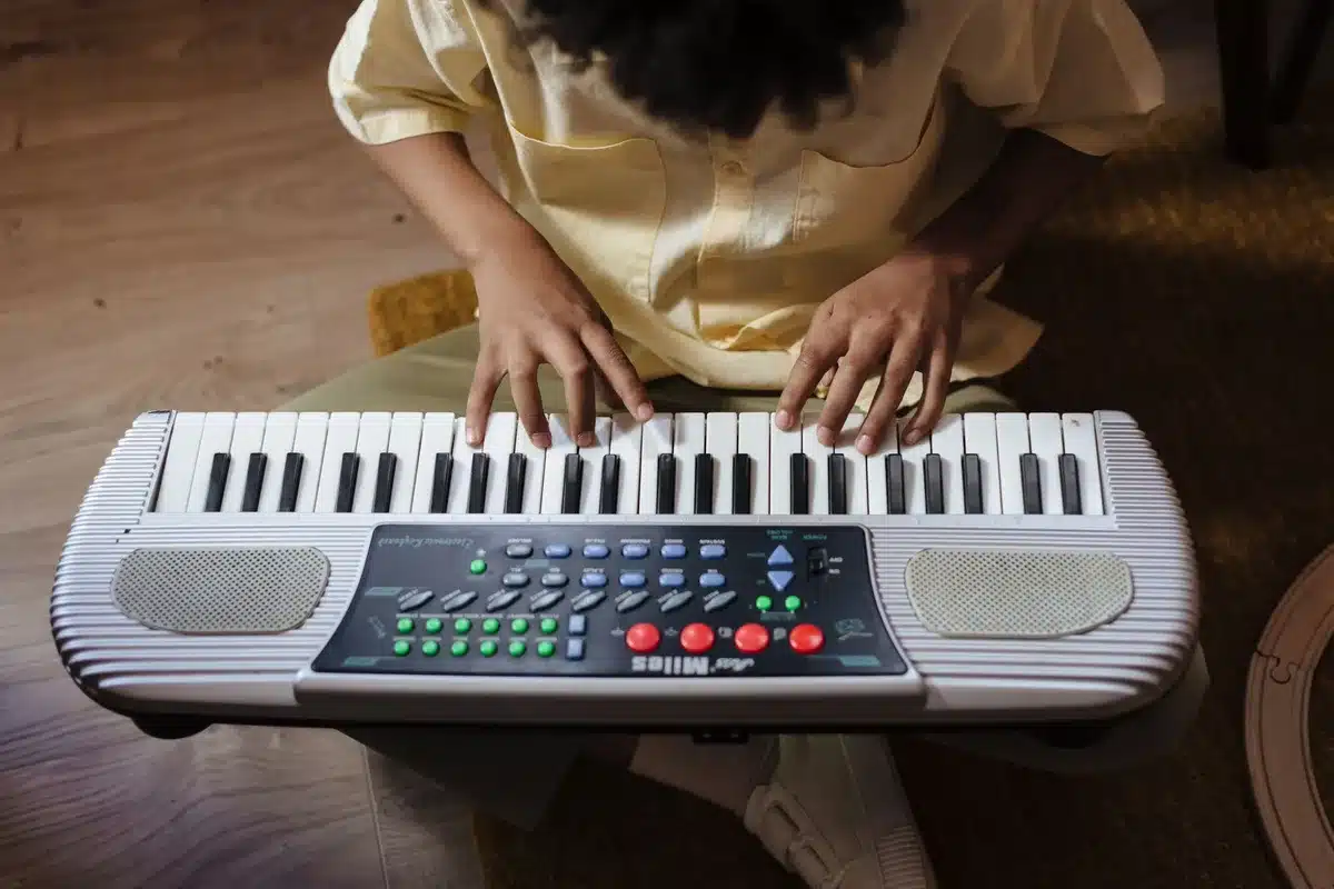 Un enfant découvrant les touches du piano avec l'aide d'un adulte.