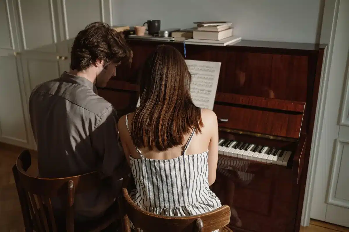 Musicien écoutant attentivement près d'un piano en studio d'entraînement auditif