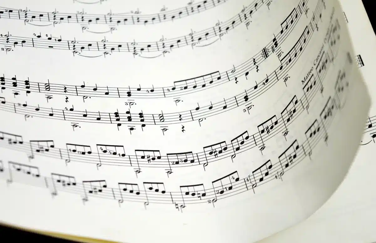 Partition musicale avec notes et altérations, lue attentivement par un musicien