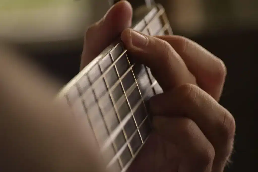 Mains d'un musicien sur les touches d'un instrument, partition floue en arrière-plan, posture concentrée