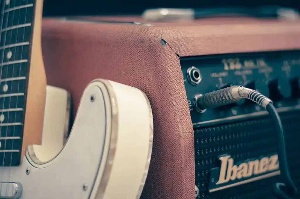 Guitare électrique demi-creuse au corps fin en cours de jeu, vue en gros plan du manche et des micros