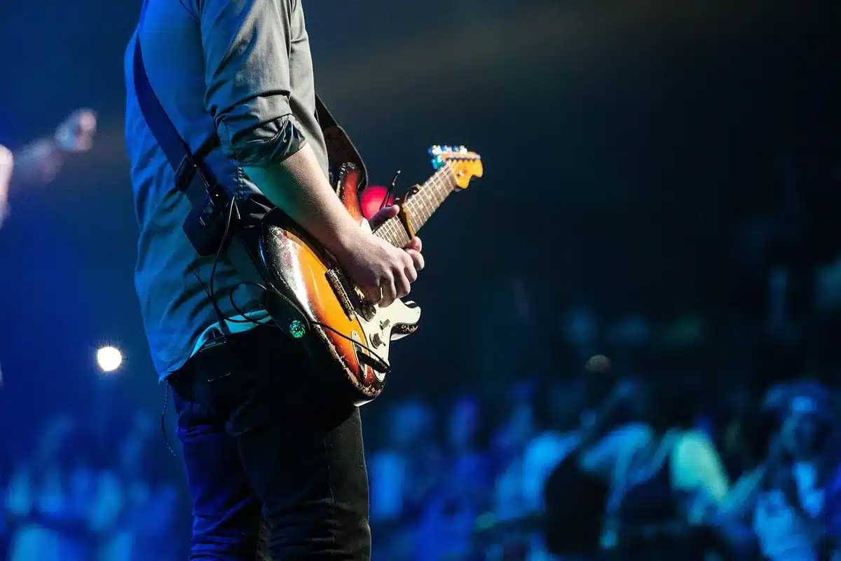 Mains testant le manche d'une guitare électrique pour évaluer confort et ergonomie