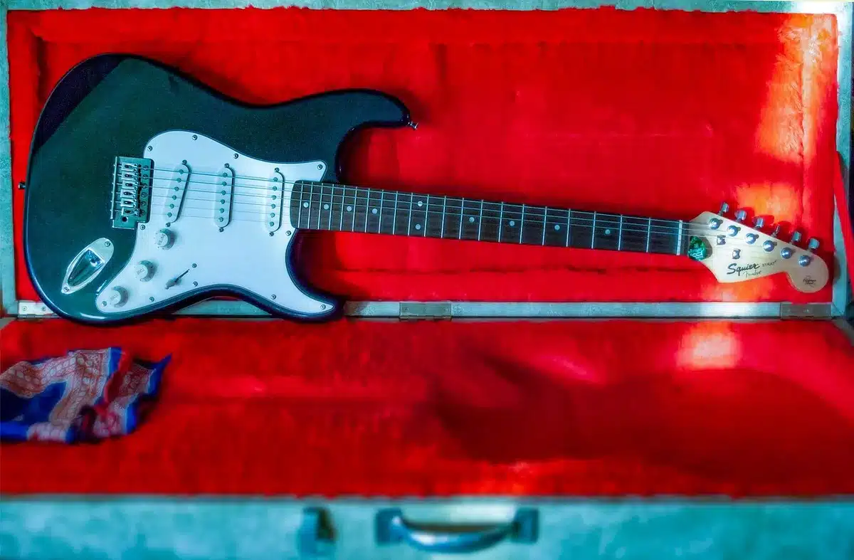 Deux guitares électriques de styles différents posées près d'un ampli pour comparer le son