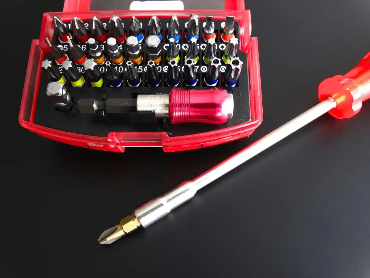 Mains assemblant un kit électronique avec tournevis et pièces en plastique